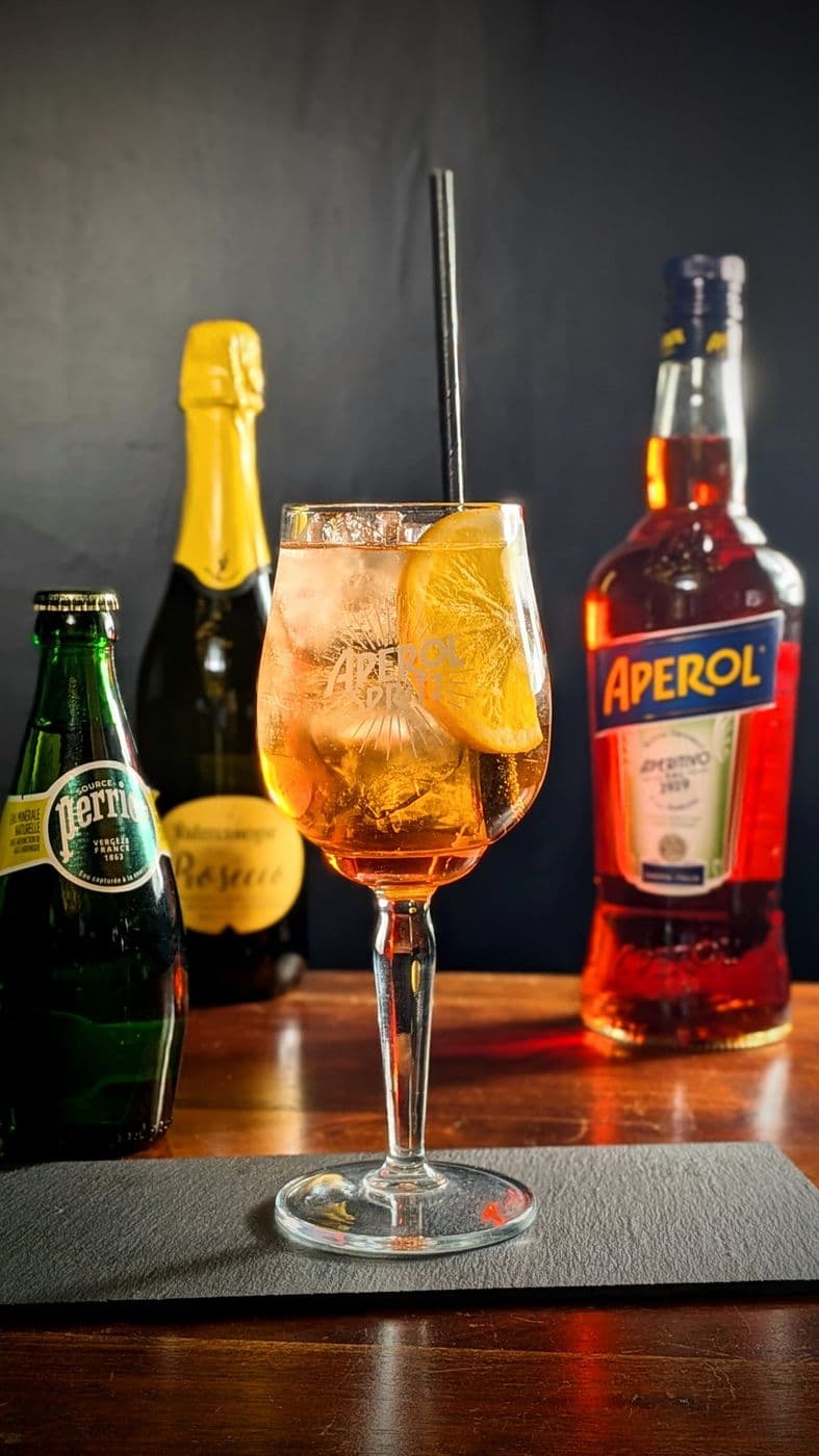 Aperol spritz dans un verre à pied, rondelle d’orange