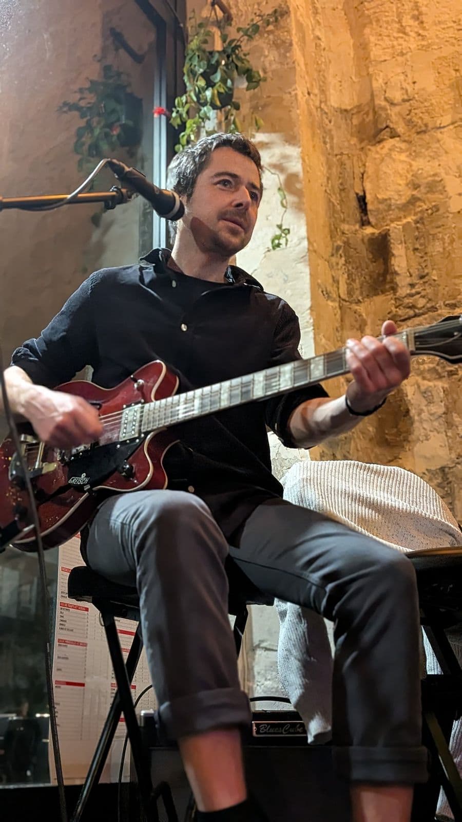 Guitariste assis pendant un set acoustique