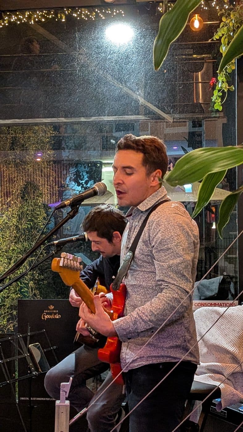 Musiciens en live devant la vitrine du bar, le soir
