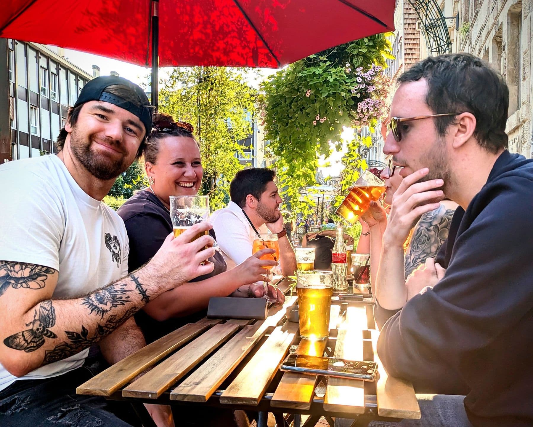Une bande de copains trinque sous le parasol rouge en fin de journée