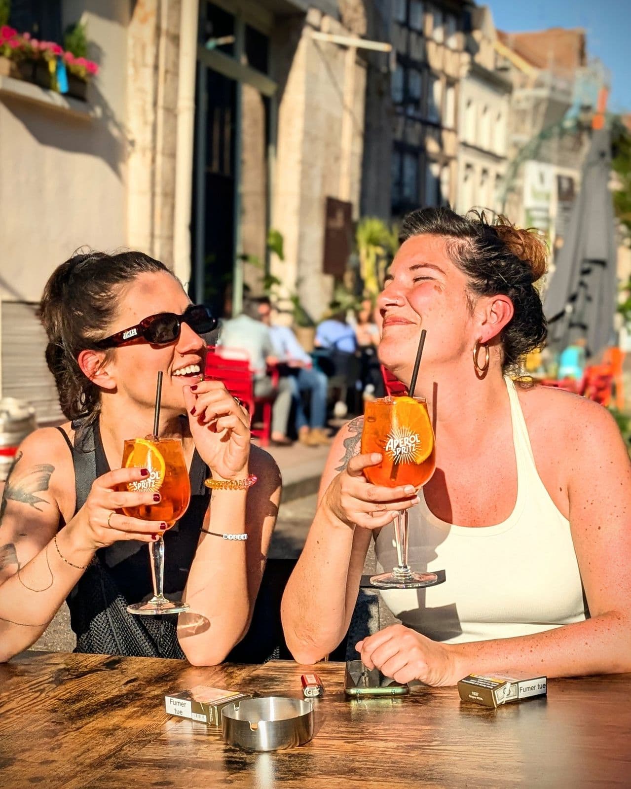 Deux amies partagent un spritz au soleil
